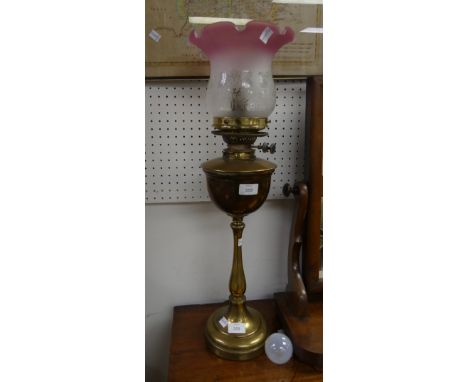 A vintage brass Oil Lamp, with pink tipped frosted glass shade, now converted for electricity, 26¼in (67cm) high.