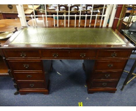A Georgian style mahogany twin pedestal Desk, the front arranged into nine various drawers, the top having an inset gilt tool