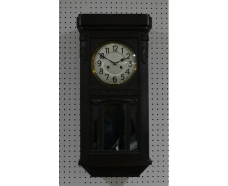 An early 20thC oak Wall Clock, circa 1920's, the silvered dial with Arabic Numerals, striking on a gong, 12in (30.5cm) wide, 