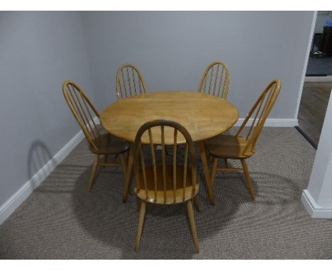 A mid 20thC Ercol elm and beech drop leaf Dining Table, the elm plank top on splayed tapering beech supports, with holographi