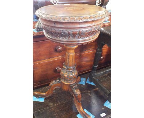 A Victorian carved Walnut and Mahogany circular work box on column and tripod supports