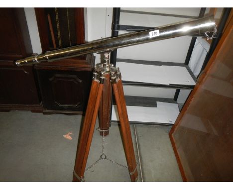 A large silver plate extending telescope on tripod.