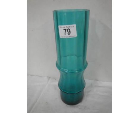 A tall slim green glass vase in the style of Whitefriars.