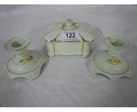 A three piece dressing table set being pair of candlesticks and trinket box.