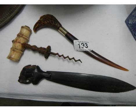 An antique corkscrew (missing brush), one other and a shoe horn.
