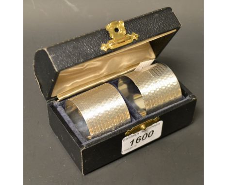 A pair of large George VI silver napkin rings, engine turned, Birmingham 1944, cased