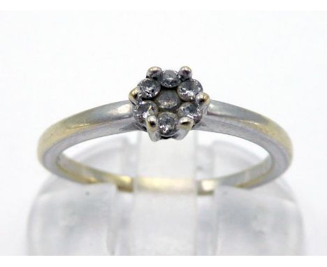 A diamond cluster ring, the small cluster 4mm diameter, to a white shank stamped '18k', finger size K/L, 2.3gms 