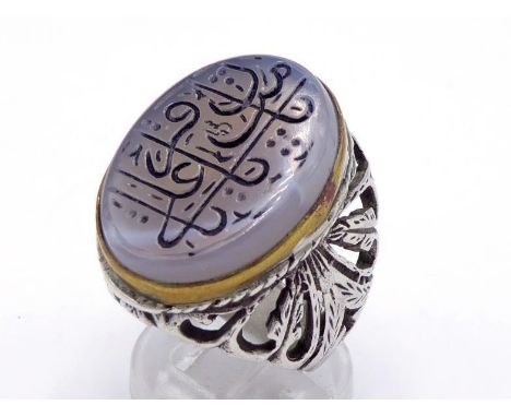 A Middle Eastern silver and agate seal ring, the oval agate cut with Arabic script, to engraved openwork shoulders, finger si