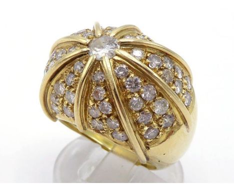 A diamond bombe dress ring, the large domed bezel centred on a 0.23 carat brilliant cut, to pave set radiating segments, the 