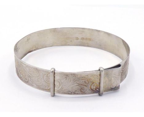 A silver bangle, hallmarked London 1970, scroll engraved overall, sliding piece to adjust, 6.2cm inner diameter, 14.3gms COND