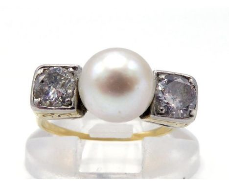 An Art Deco diamond and pearl (untested) ring, the 7.5mm central round pearl between two platinum box set brilliants, to a ye