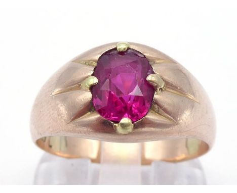 A gentleman's yellow metal (tests 14 carat gold) and synthetic ruby set ring, the oval cut stone claw set above a broad shank