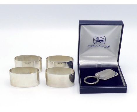 A set of four plain oval silver napkin rings by Roberts & Dore Ltd., Sheffield, 2005; also a modern silver key ring of tablet