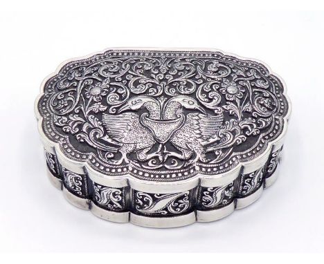 A good silver box of escutcheon form with wavy edges, probably Indian or Ceylonese, late19th century, chased in low relief wi