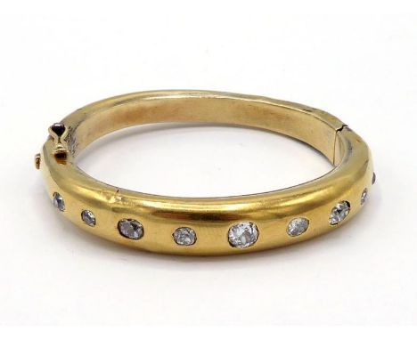 A Victorian diamond bangle, gypsy set to the front with graduated mine cuts, the central stone approx. 0.40 carat, open backe