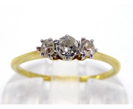 A three stone diamond ring, the central graduated old cuts and flanking single cuts claw set above a slim shank, stamped '18k