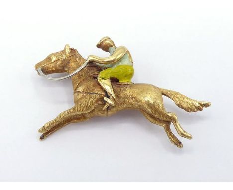 EQUESTRIAN INTEREST: an 18 carat gold and enamel brooch, modelled as a horse and rider, stamped '750' verso, 4cm long, 6.5gms