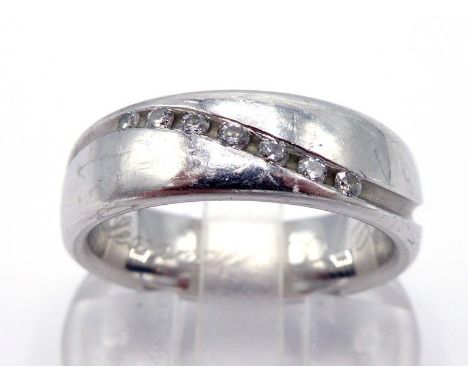 A diamond ring, the wide band cut with an undulating groove, tension set along part with seven small brilliants totalling app