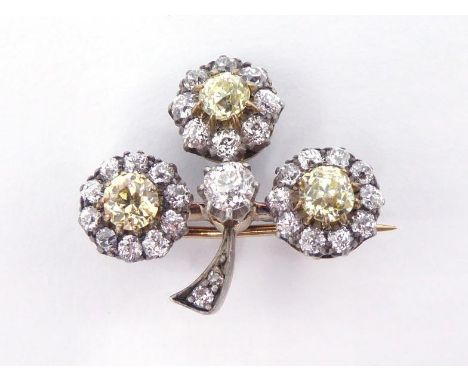 A late Victorian diamond clover brooch, circa 1890, each leaf centred on a fancy yellow mine cut in a surround of smaller min