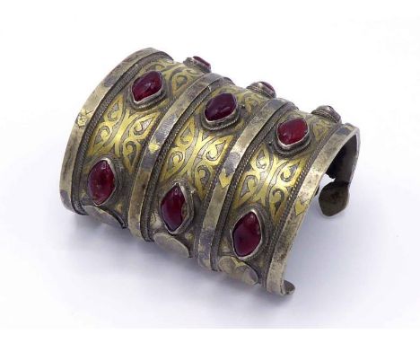 A North African two colour metal and paste cuff bangle, with inlaid and engraved three-band construction, 8cm long CONDITION: