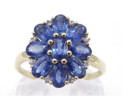 A 9 carat gold, sapphire and diamond cluster ring, the cluster composed of nine oval cut sapphires, accented with small brill