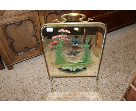 A brass and bevelled edged mirrored fire screen with painted bird decoration