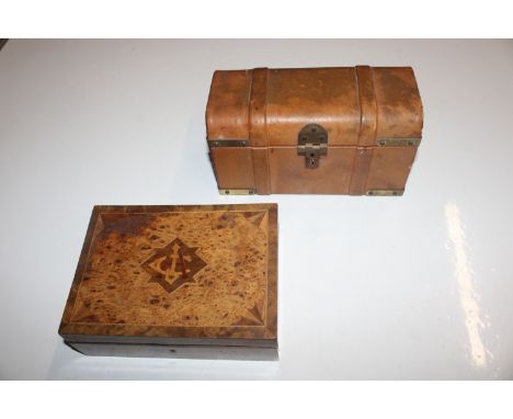 A leather covered jewellery chest in the form of a trunk and a wooden inlaid box, the lid inset with white metal presentation