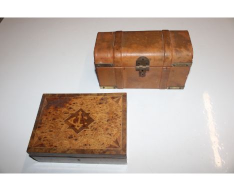 A leather covered jewellery chest in the form of a trunk and a wooden inlaid box, the lid inset with white metal presentation