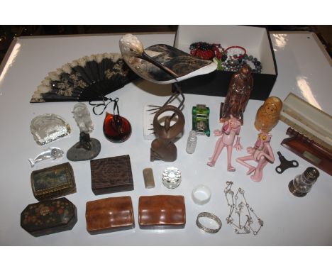 A box containing Pink Panther figures; Russian doll; Henry Moore style carving; a table lighter in the form of a knight; a Sw