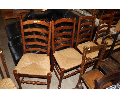 A set of six oak and rush seated ladder back dining chairs