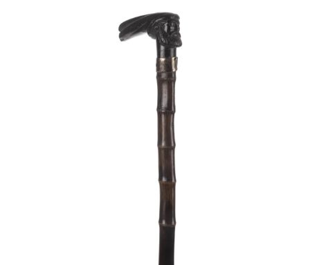 *Walking Cane. Carved walking stick,  the knop carved with a bearded gentleman with a long headpiece, on a bamboo shaft with 