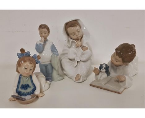 FOUR NAO FIGURINESincluding a boy with his puppy, reading a book, 18cm long, child wrapped in a blanket, 16.5cm high, boy in 