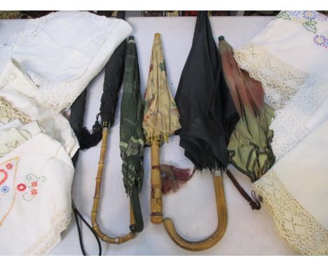 A quantity of vintage umbrellas and parasols, together with vintage table linen 