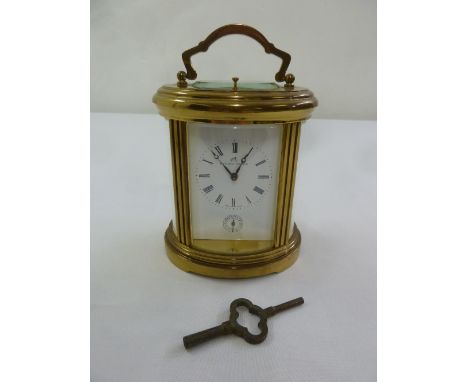 Matthew Norman an oval brass repeating carriage clock with hinged carrying handle and key