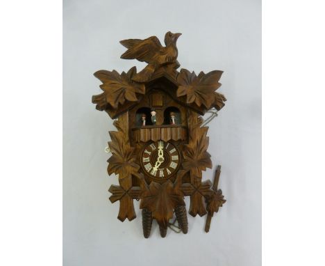 Black Forest cuckoo clock profusely carved with birds and leaves to include three weights and pendulum