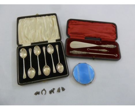 A cased set of six silver teaspoons, a cased shoehorn and two button hooks with silver handles, and a silver and enamel compa