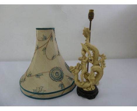 Chinese composition table lamp with a figurine of a man slaying a dragon, to include silk shade