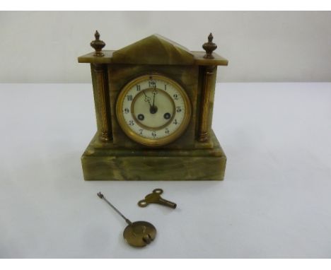 An early 20th century onyx mantle clock of architectural form, two train movement, enamel dial with Arabic numerals, to inclu