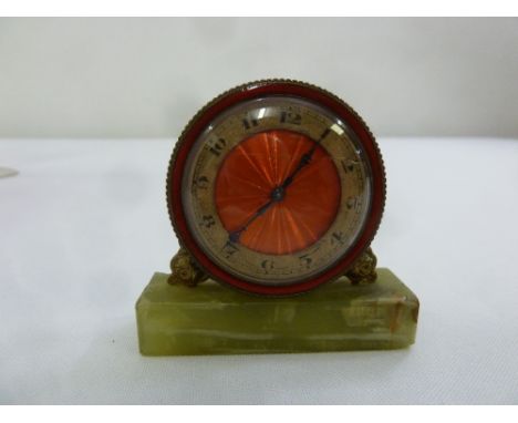 An early 20th century miniature circular desk clock, silvered dial with Arabic numerals mounted on an onyx base, A/F