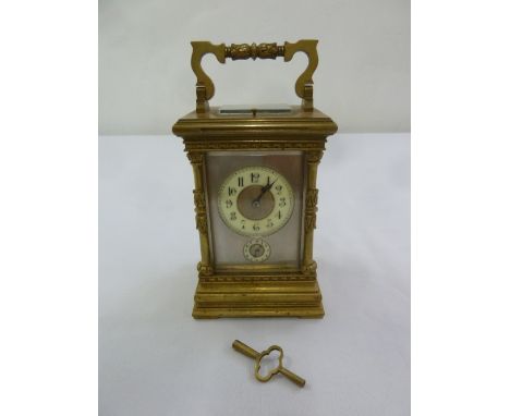 A brass repeating carriage clock with subsidiary second hand and scroll carrying handle