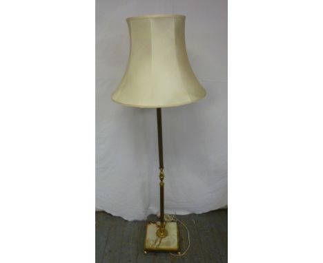 A brass and onyx standard lamp on square base with four brass feet to include silk shade