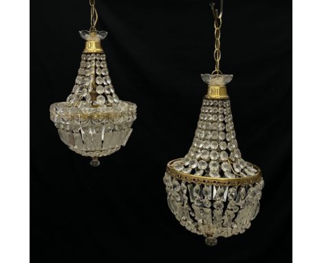 Two French Empire style chandeliers each having a flowerhead finial on a brass collar above a cascade of faceted graduating g