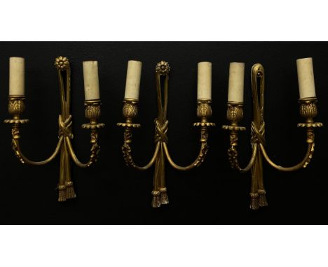 A set of three French 19th century style gilt metal wall sconces each having a flowerhead finial draped with a knotted rope b