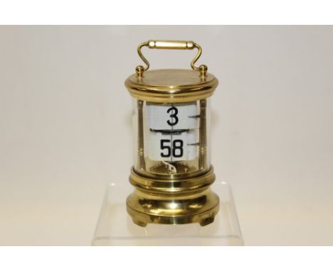 Ticket clock with base mounted movement in a gilt metal case   CONDITION REPORT  Clock mechanism ticks. Numbers move 