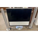 Bang & Olufsen TV with floor standing speakers & a remote control