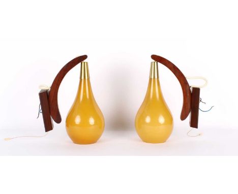Pair of Scandinavian Teak Wall Lights Circa 1970s, the curved brackets suspending caramel glass shades.30cm high, 22cm deepLi