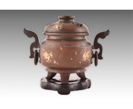 A Chinese Qing dynasty bronze and gold splash censor and cover, with pierced cover, with scrolled ring handles and supported 