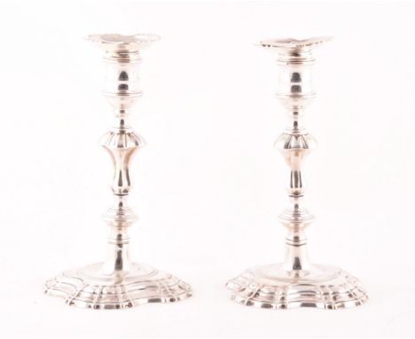 A pair of George II silver candlestick holders, ornately decorated, hallmarked London, possibly 1748, by 'D:E', each 19.5cm h