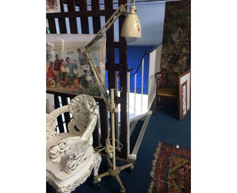 An angle poise lamp, on four wheel trolley stand