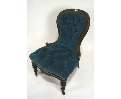 A Victorian button back upholstered nursing chair. With spoon-shaped back, upholstered in turquoise velvet, with scroll carve